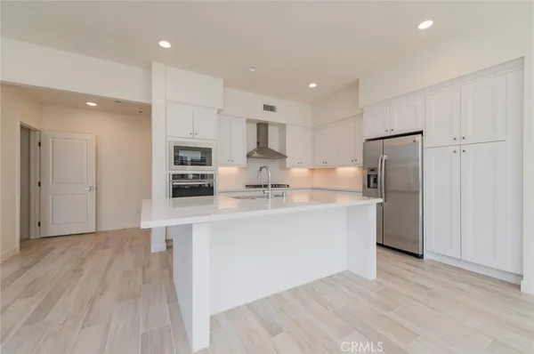 a kitchen with stainless steel appliances granite countertop a refrigerator and a stove top oven