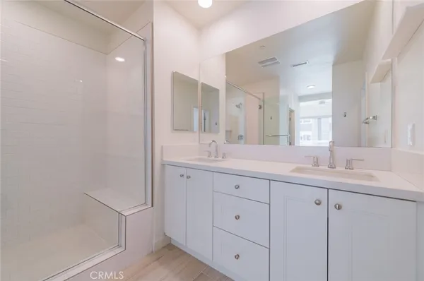 a bathroom with double sink and a mirror
