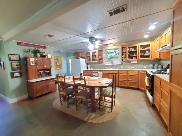 a dining area with stainless steel appliances a table and chairs