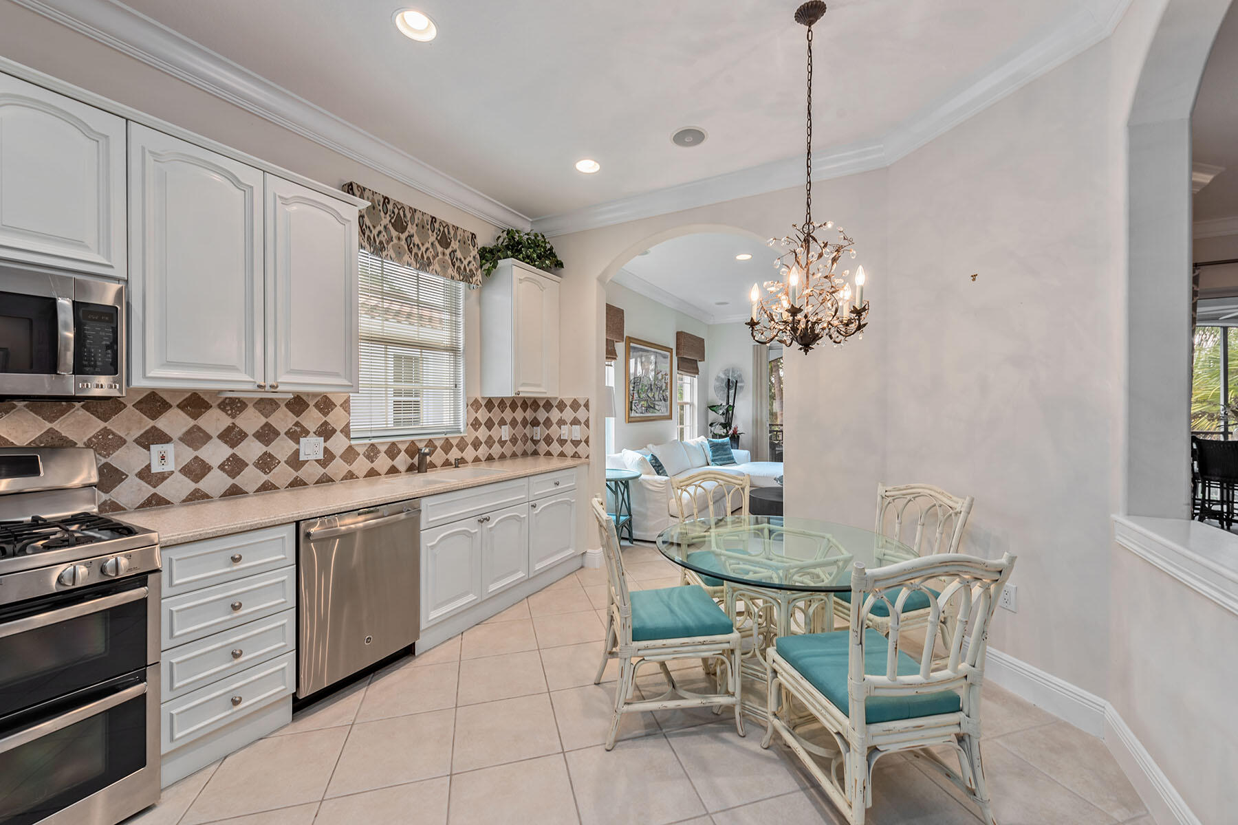 9110 Cascada Way, Unit 201 Naples, FL 34114 - Photo 2 of 50 a kitchen with stainless steel appliances granite countertop a sink a stove a dining table and chairs