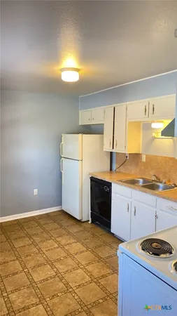 a kitchen with granite countertop a sink and a stove top oven