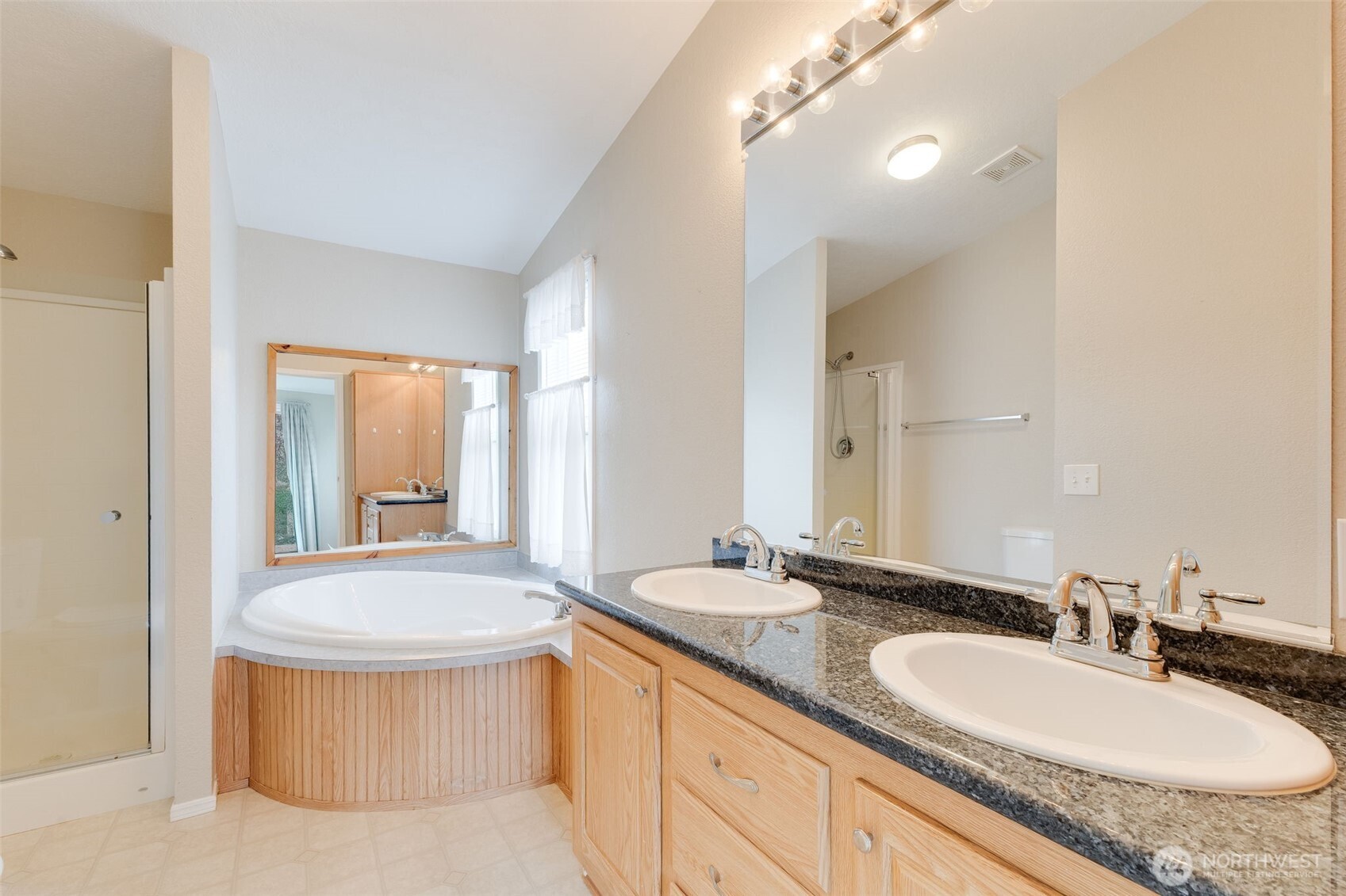 10420 197th Street East Graham, WA 98338 - Photo 11 of 21 a bathroom with a granite countertop tub sink and mirror