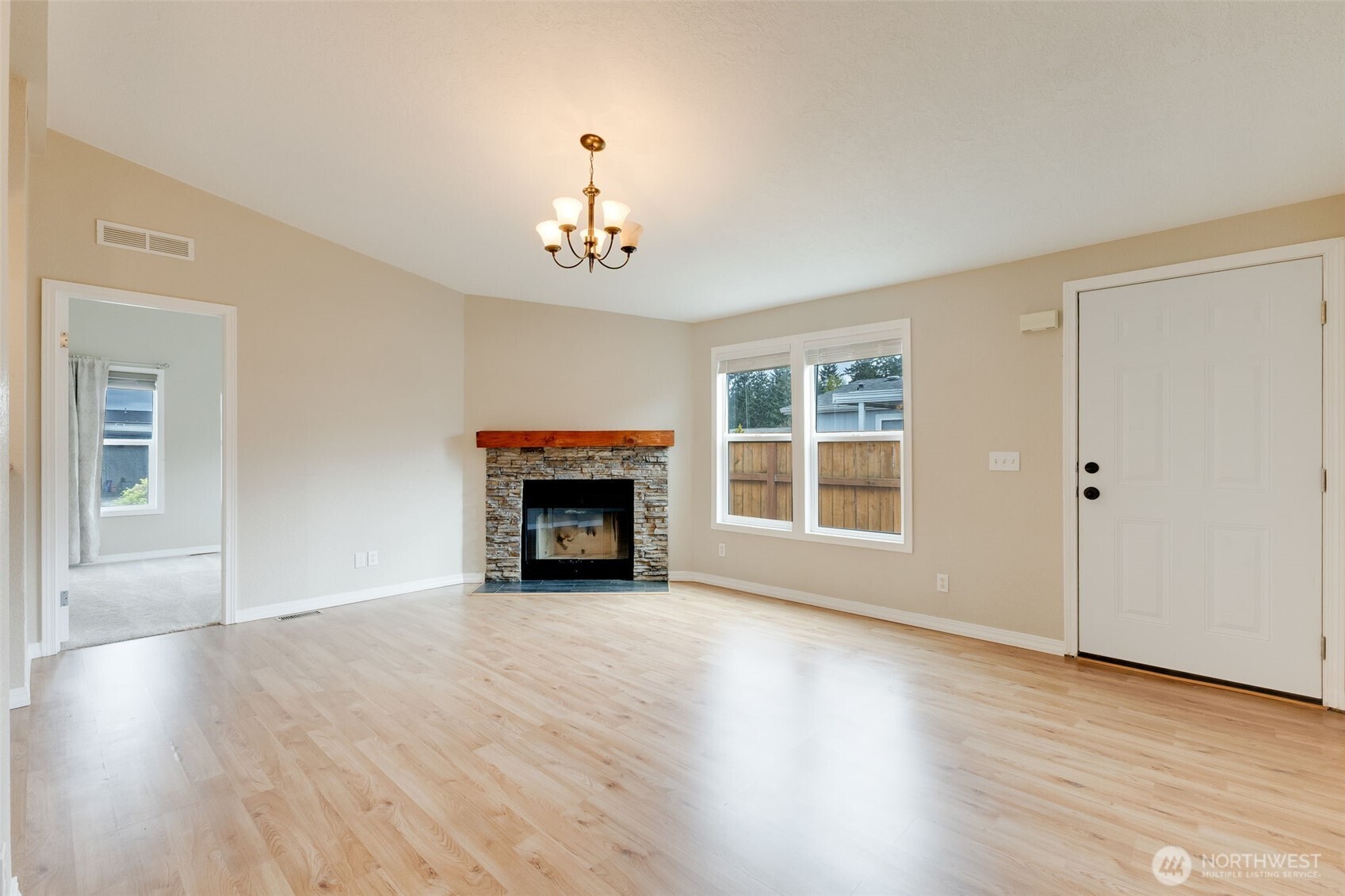 10420 197th Street East Graham, WA 98338 - Photo 6 of 21 an empty room with windows fireplace and wooden floor