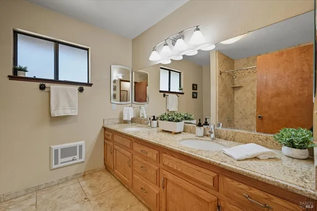 a en suite bathroom with a double vanity sink and a mirror
