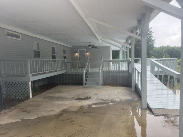 1100 Pine Top Road Toone, TN 38381 - Photo 32 of 40 Covered patio with concrete flooring, featuring a ramp and stairs leading to the deck