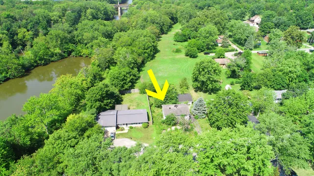 an aerial view of a house with a yard and lake view