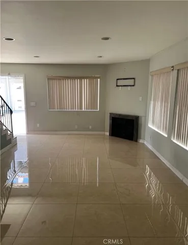 a view of an empty room with a fireplace and a window