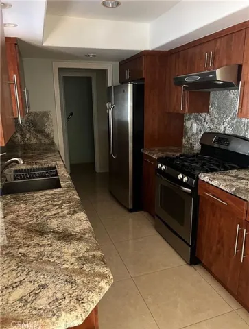 a kitchen with stainless steel appliances granite countertop a stove a refrigerator and a microwave