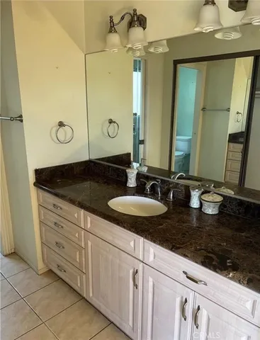 a bathroom with a granite countertop sink and a mirror