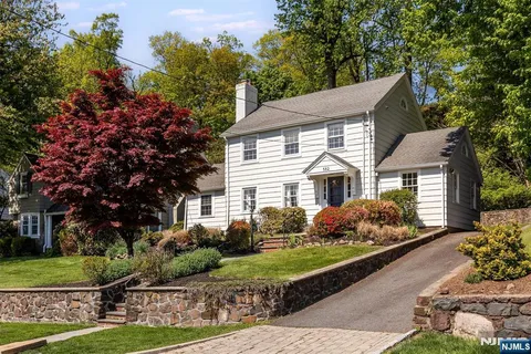 a front view of a house with a yard and potted plants