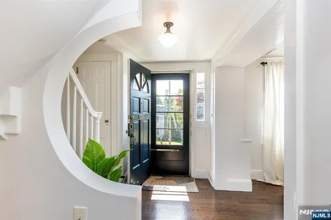a view of a hallway with wooden floor and entryway