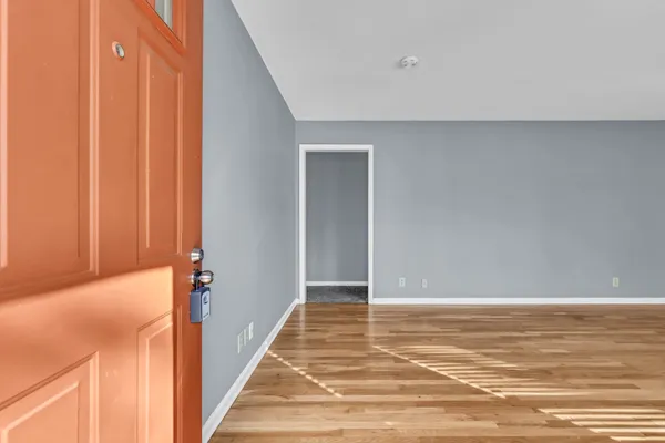a view of a livingroom with an empty space and wooden floor