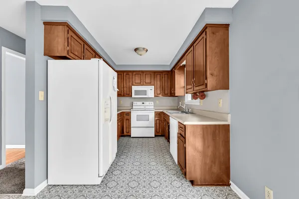 a kitchen with stainless steel appliances granite countertop a refrigerator a stove top oven a sink and dishwasher