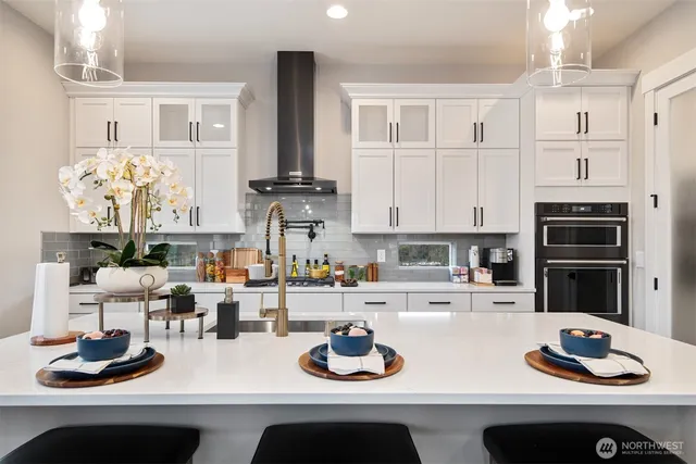 a kitchen with white cabinets and appliances