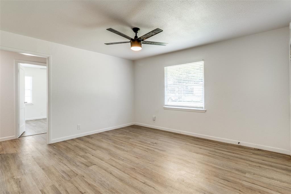 2351 Healey Drive Dallas, TX 75228 - Photo 3 of 12 a view of an empty room with wooden floor and a window