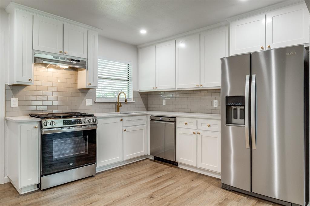 2351 Healey Drive Dallas, TX 75228 - Photo 4 of 12 a kitchen with granite countertop white cabinets and stainless steel appliances