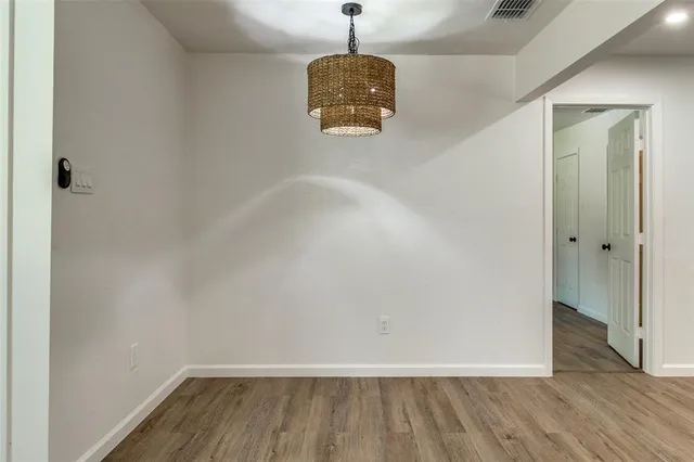 a view of a hallway with wooden floor and a window