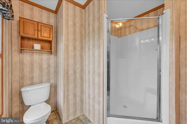 a bedroom with a bed and a flat tv screen on dresser