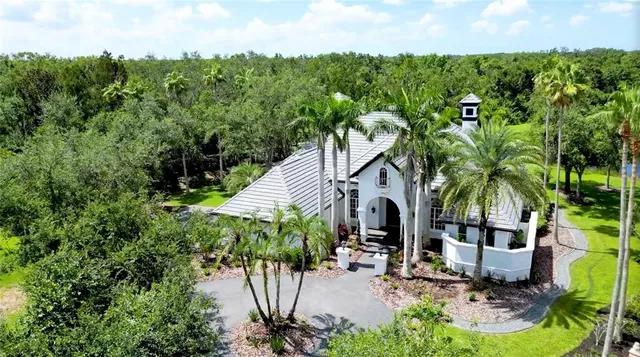 a front view of a house with garden and trees