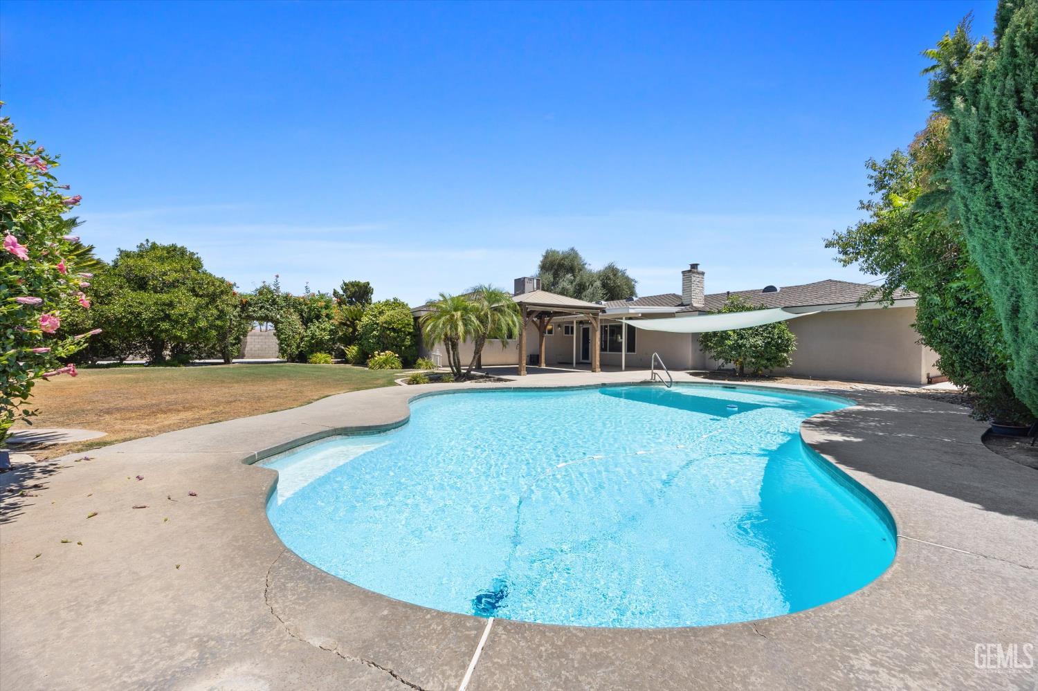 Undisclosed Address Bakersfield, CA 93308 - Photo 12 of 50 a view of a swimming pool with a yard