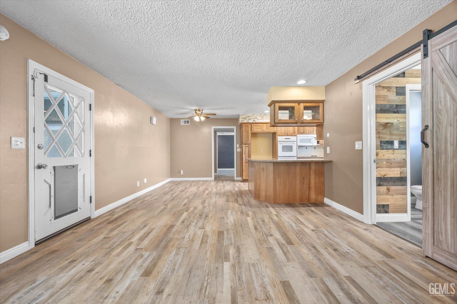 Undisclosed Address Bakersfield, CA 93308 - Photo 24 of 50 a view of a big room with wooden floor kitchen view and windows