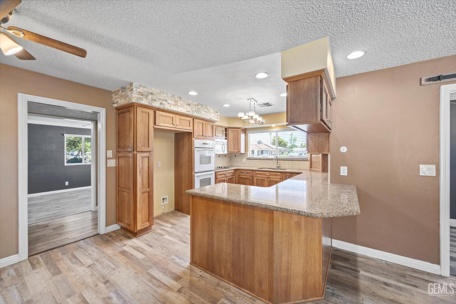 Undisclosed Address Bakersfield, CA 93308 - Photo 28 of 50 a large kitchen with kitchen island a counter top space a sink and stainless steel appliances