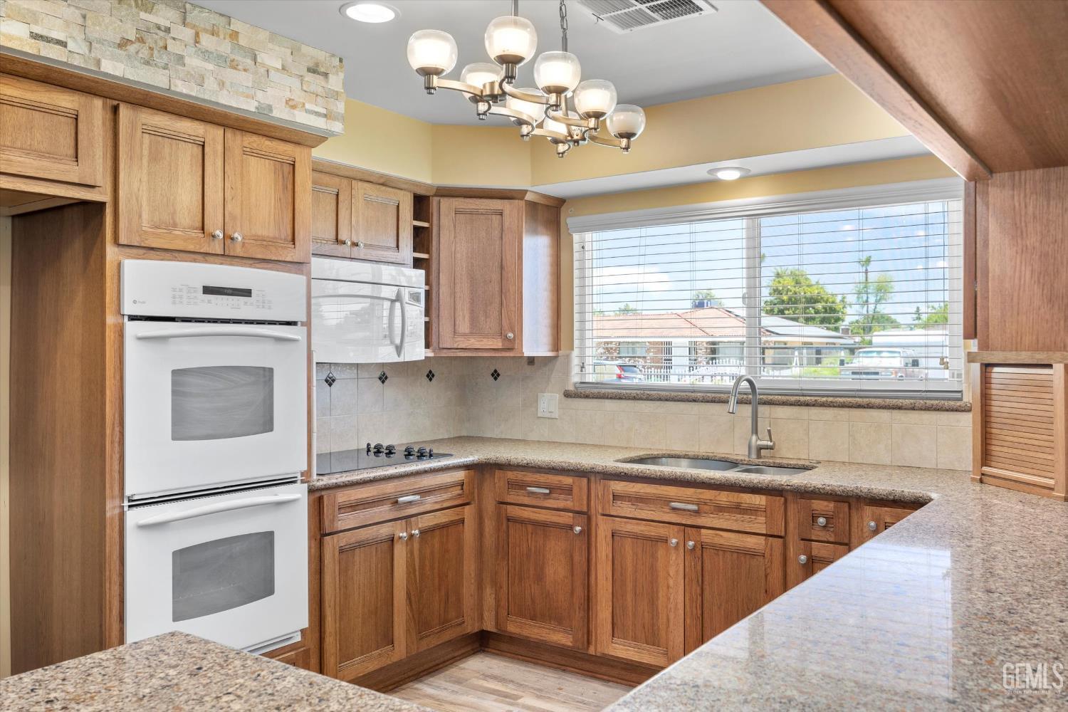 Undisclosed Address Bakersfield, CA 93308 - Photo 30 of 50 a kitchen with stainless steel appliances granite countertop a sink dishwasher a stove and a refrigerator with wooden cabinets