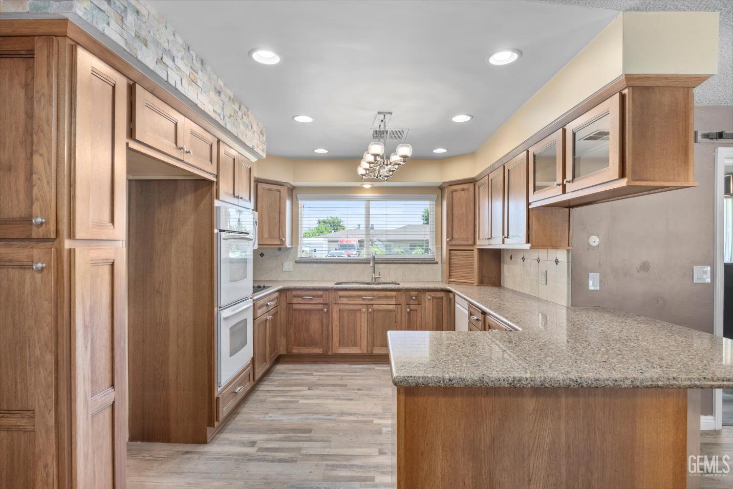 Undisclosed Address Bakersfield, CA 93308 - Photo 5 of 50 a kitchen with granite countertop a refrigerator and wooden cabinets