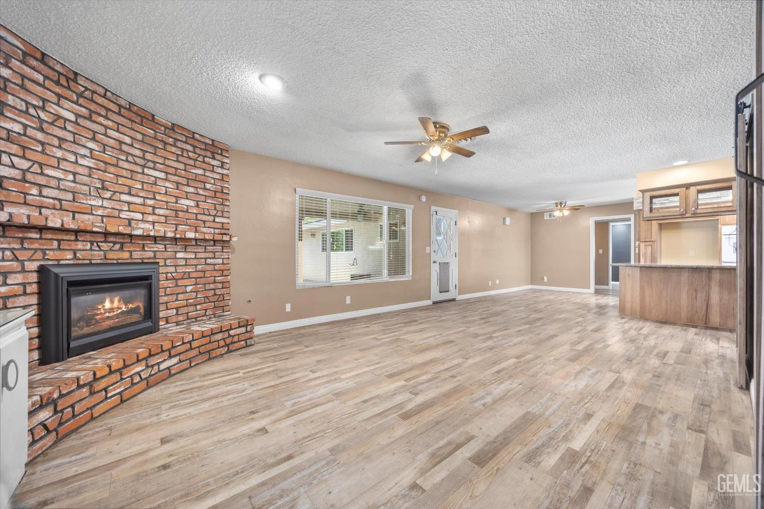 Undisclosed Address Bakersfield, CA 93308 - Photo 6 of 50 a view of an empty room with a fireplace and a window