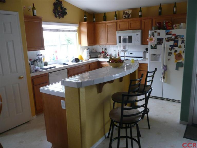2451 Bicknell Avenue Santa Maria, CA 93458 - Photo 7 of 10 a kitchen with stainless steel appliances kitchen island a table chairs in it and a window