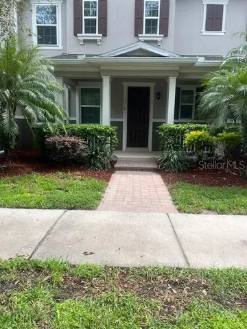 a view of a white house with a small yard and plants