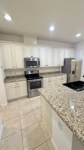 a kitchen with a stove a sink and a refrigerator