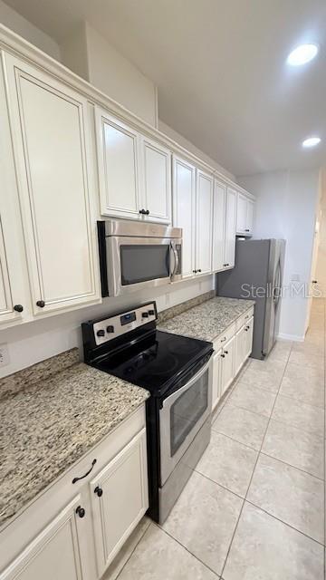 13718 Beckman Drive Windermere, FL 34786 - Photo 12 of 20 a kitchen with granite countertop a stove a sink and a refrigerator