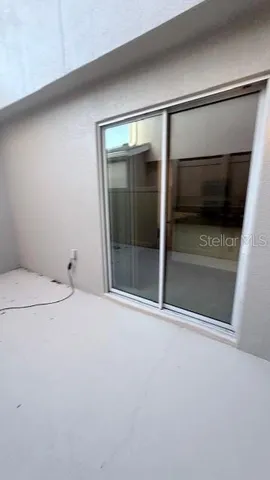 a view of an empty room with a fireplace and wooden floor