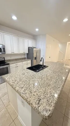 a kitchen with a sink refrigerator and cabinets
