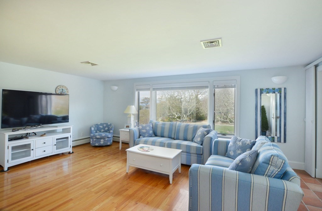 46 Gunning Point Road, Unit 2 Falmouth, MA 02540 - Photo 9 of 29 a living room with furniture and a flat screen tv
