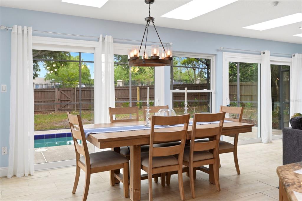 7432 Sparkling Lake Road Orlando, FL 32819 - Photo 15 of 54 a dining room with furniture large windows and a chandelier