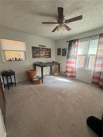 a view of a livingroom with furniture and a ceiling fan