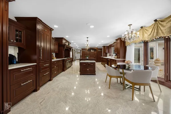 a kitchen with stainless steel appliances kitchen island granite countertop a refrigerator and cabinets
