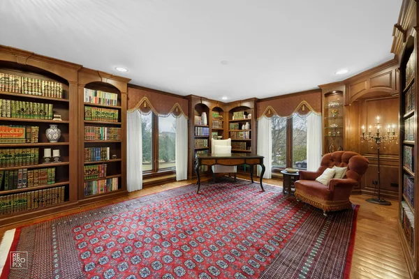 a living room with furniture a bookshelf and a large window