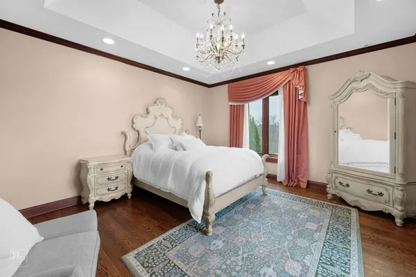 a bedroom with a large bed and a chandelier