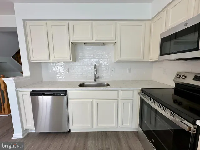 a kitchen with stainless steel appliances granite countertop a sink a stove and a microwave