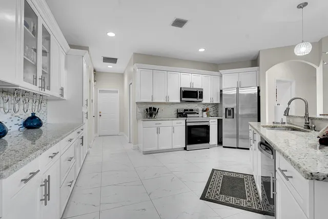 a large white kitchen with cabinets