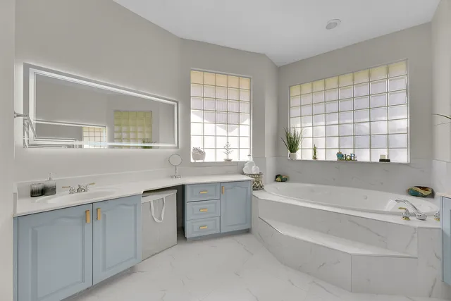 a kitchen with white cabinets and window