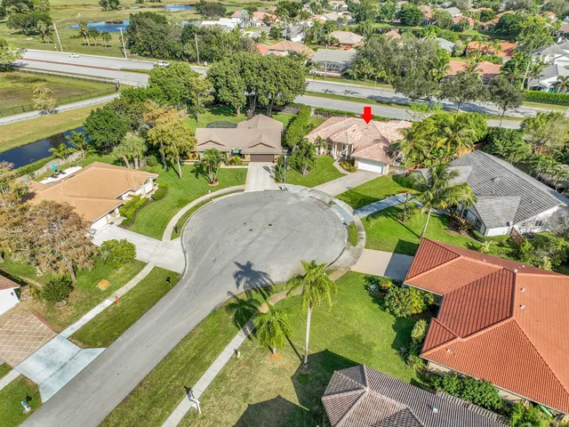 an aerial view of a house with a yard and lake view