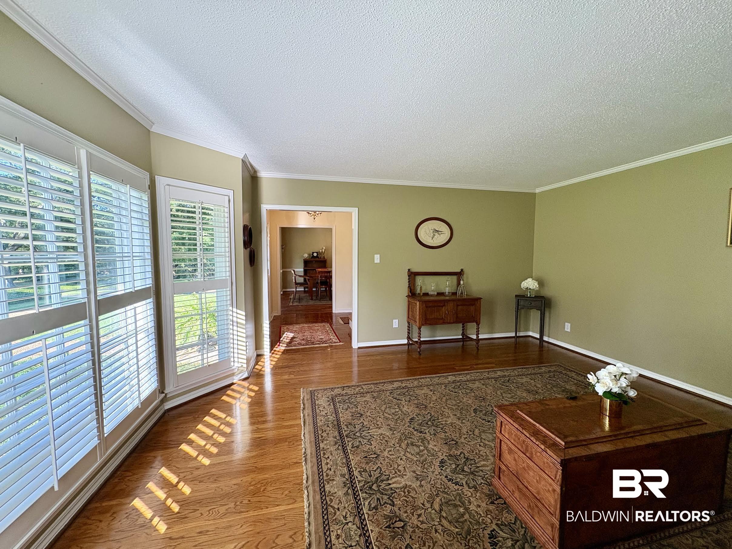 6105 Brandy Run Road South Mobile, AL 36608 - Photo 5 of 45 Living area featuring a textured ceiling, wood finished floors, crown molding, and baseboards