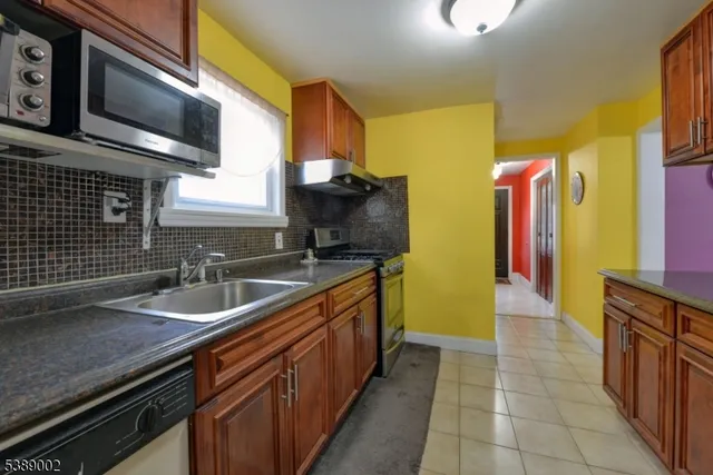 a kitchen with stainless steel appliances granite countertop a sink and a microwave