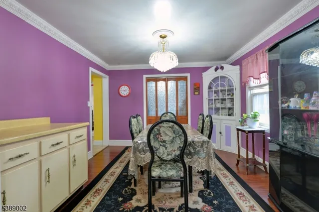 a view of a dining room with furniture a chandelier and wooden floor