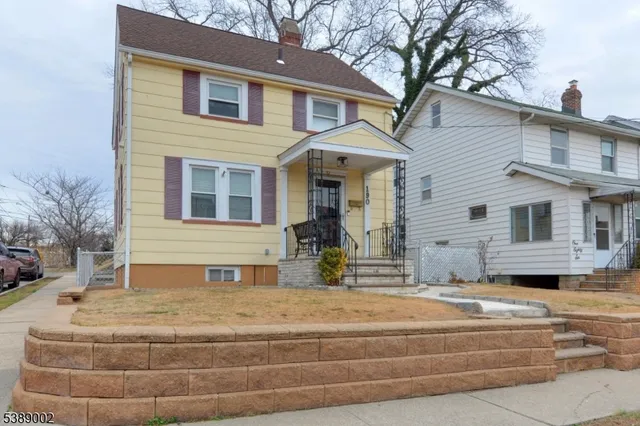 a front view of a house with large trees