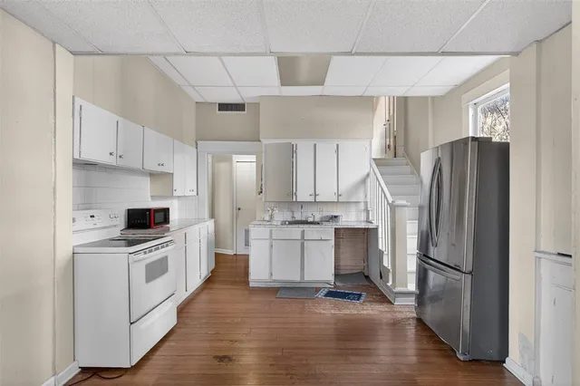 a kitchen with a refrigerator a sink and a stove top oven